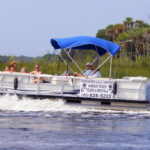 River Safaris tour pontoon boat with several young children at the bow